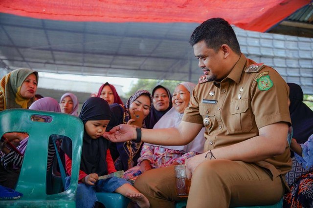 Wali Kota Medan Bobby Nasution makan siang bersama warga usai peletakan batu pertama proyek Medan Islamic Center di Medan Labuhan pada Senin (22/5). Foto: Pemkot Medan